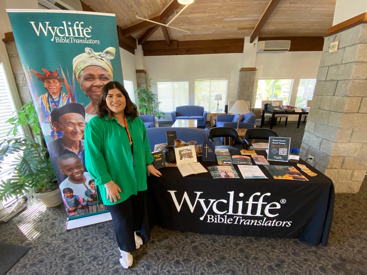 Stephanie standing in front of a presentation table at an event